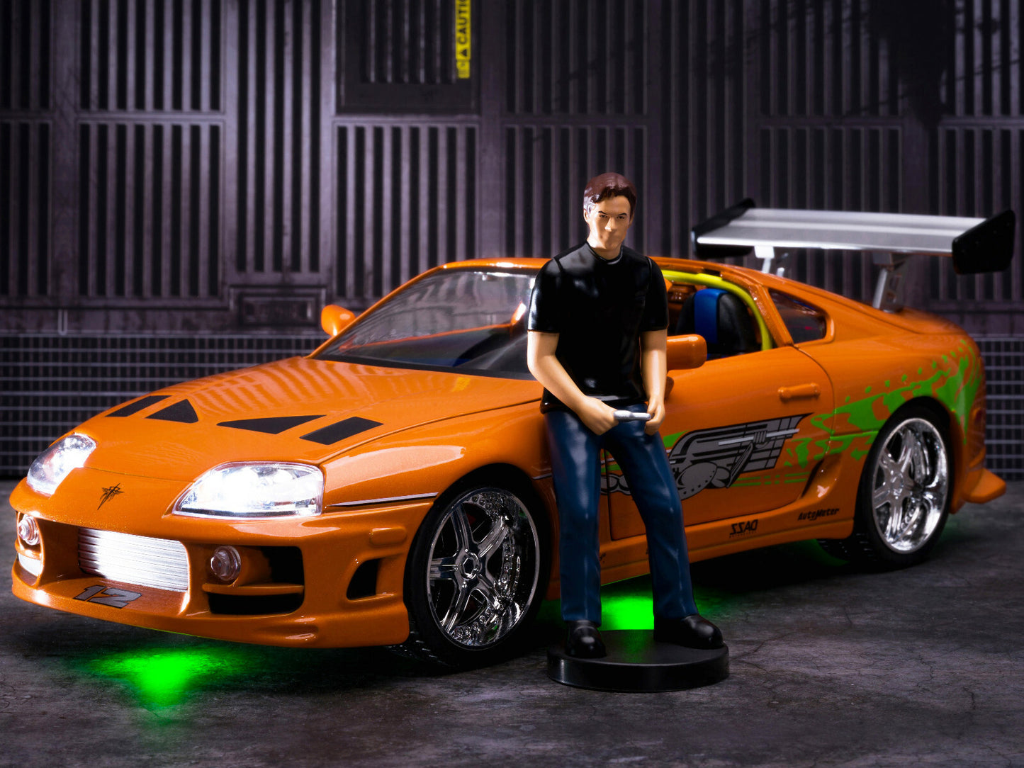 Orange sports car with a person standing next to it in a dark setting