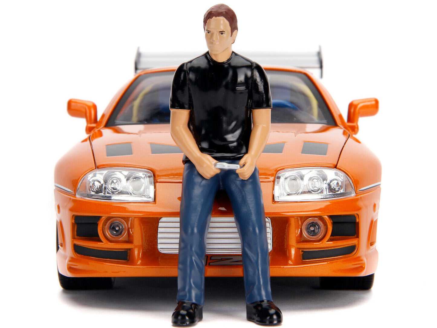 Model figure of a person standing in front of an orange car on a white background