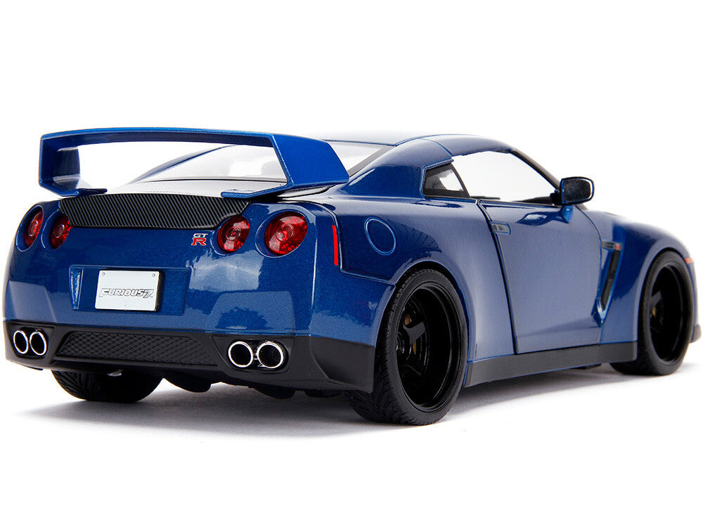 Blue sports car with a prominent rear wing on a white background