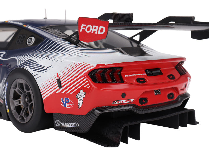 Back view of a red and white Ford race car with visible branding on a white background