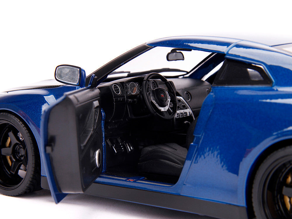 Close-up of a blue sports car with open door on a white background