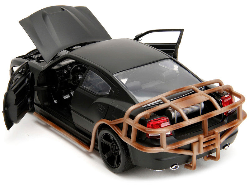 Black model car with open doors and a brown bumper on a white background