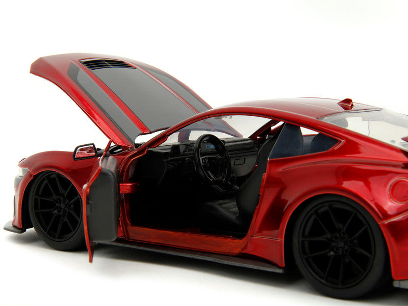 Red sports car model with open door on a white background