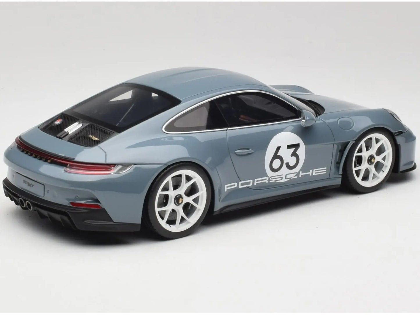 Model car of a Porsche 911 with the number 63 on a white background
