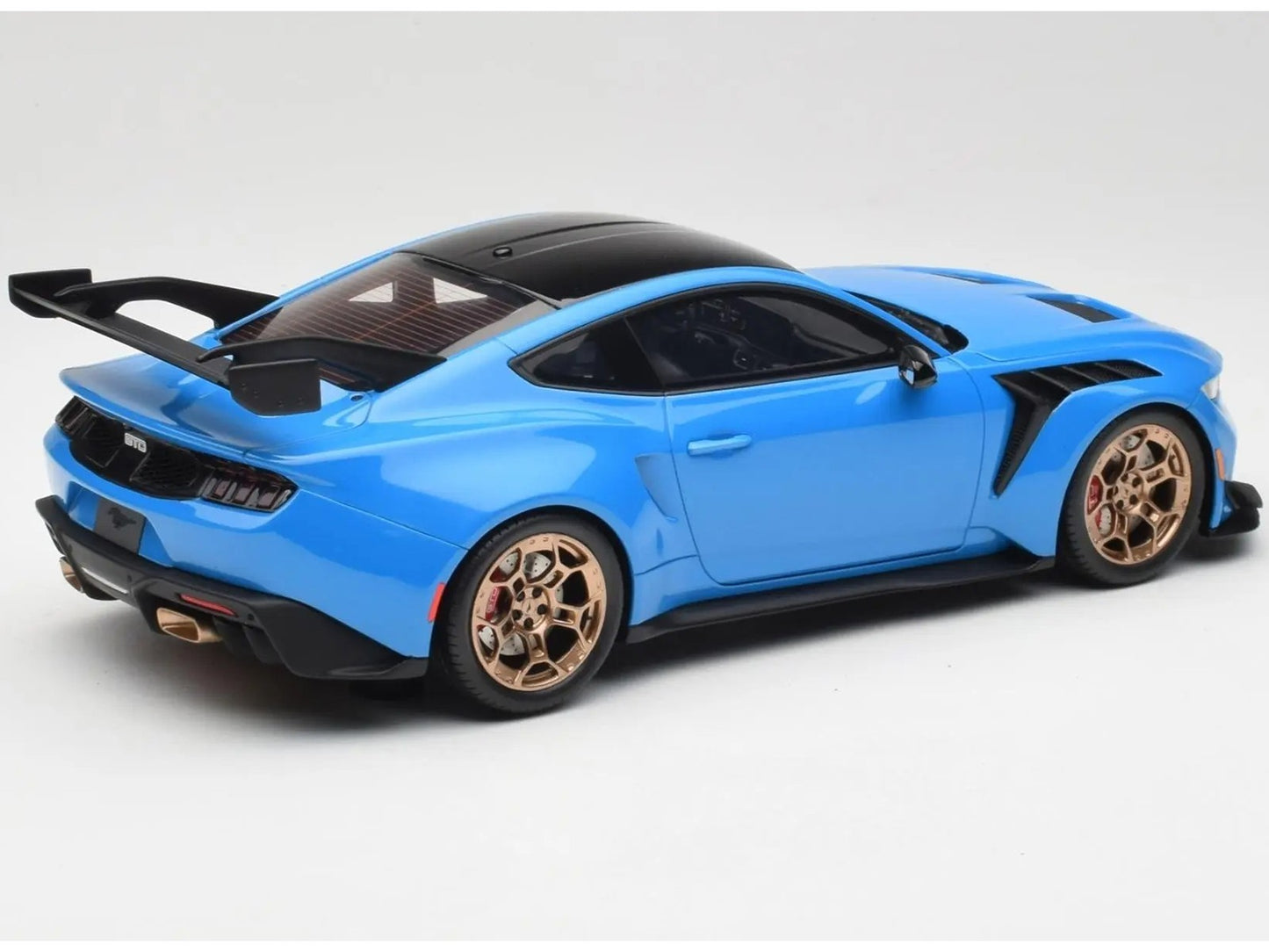Blue sports car model with gold wheels on a white background