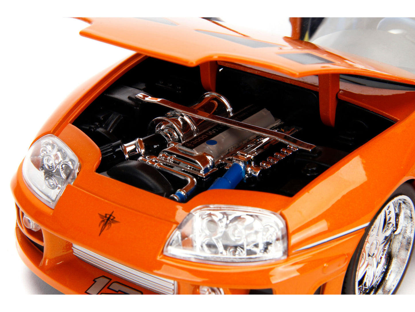Close-up of an orange toy car with open hood showing detailed engine model.