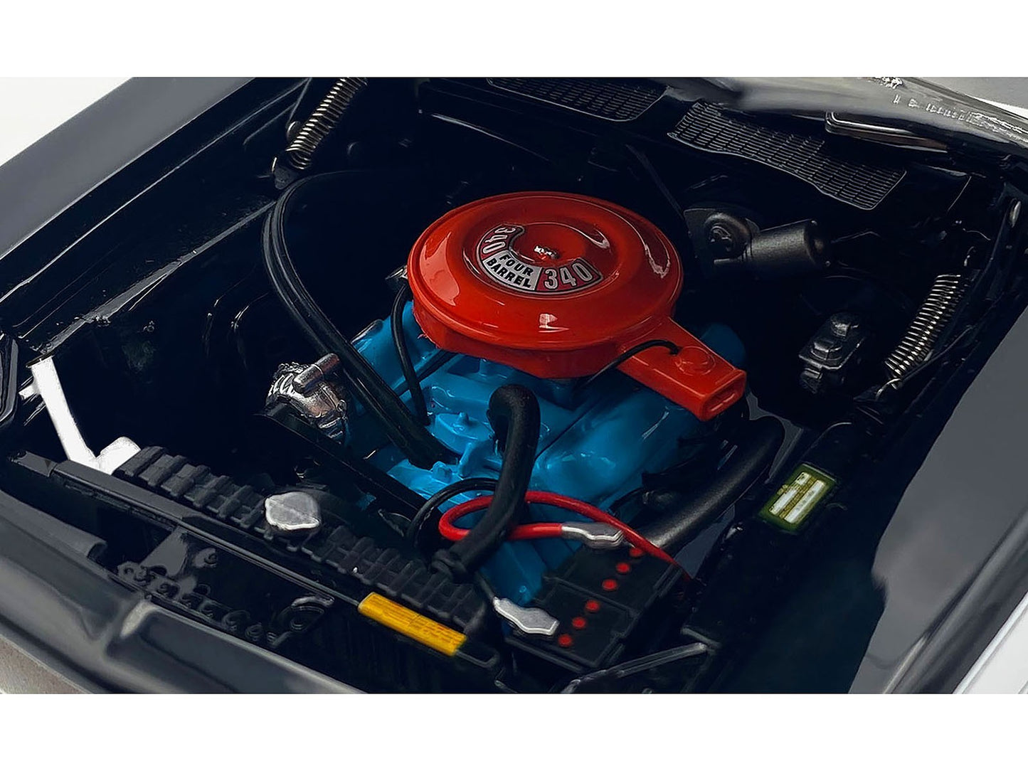 Engine compartment of a vehicle with a red cap and blue engine block.