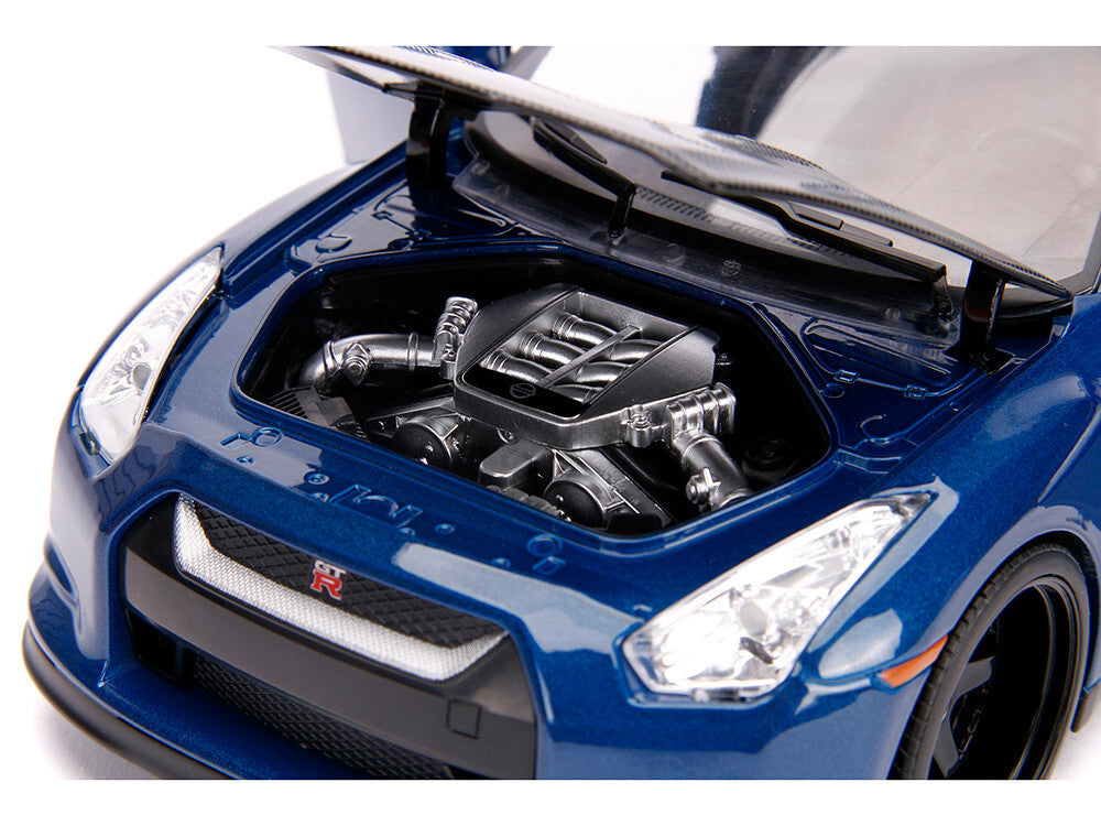Blue car with open hood showing engine details on a white background