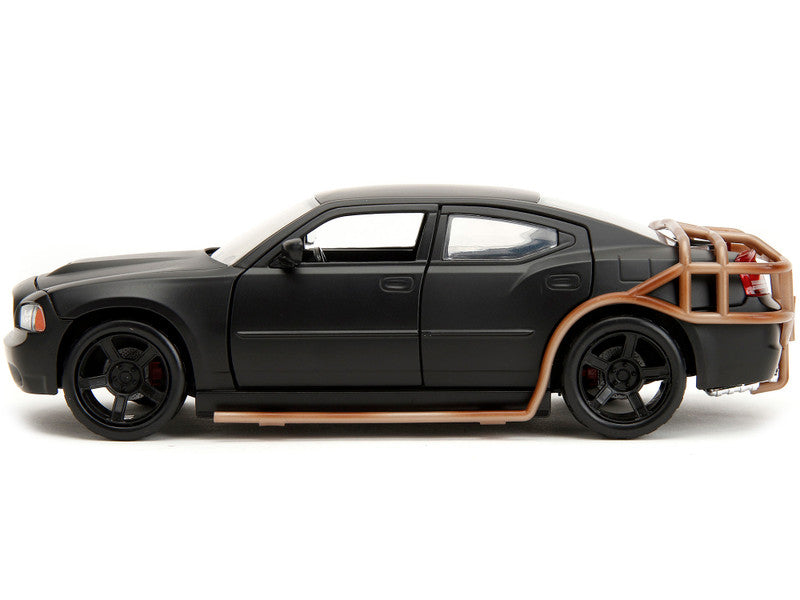 Black model car with wooden side panels on a white background