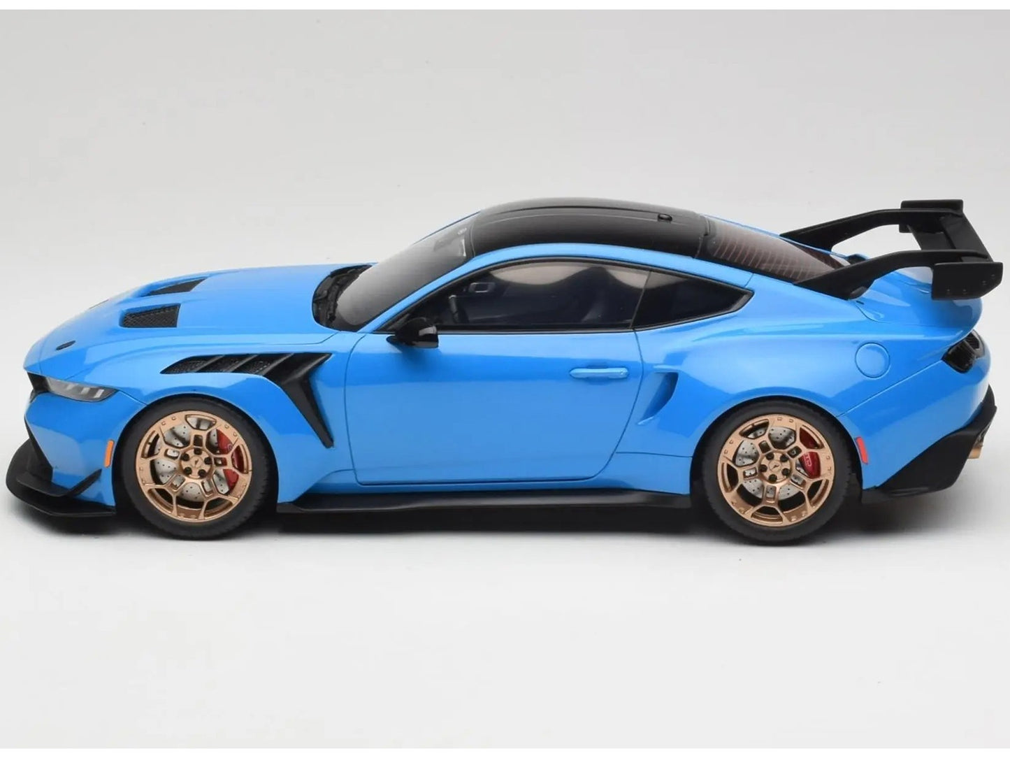 Blue sports car model with gold wheels on a white background