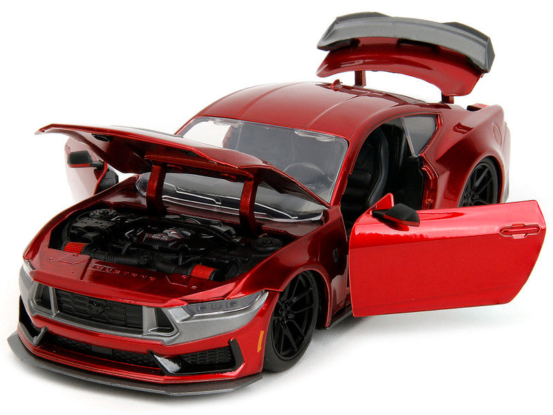 Red model car with open doors and hood on a white background