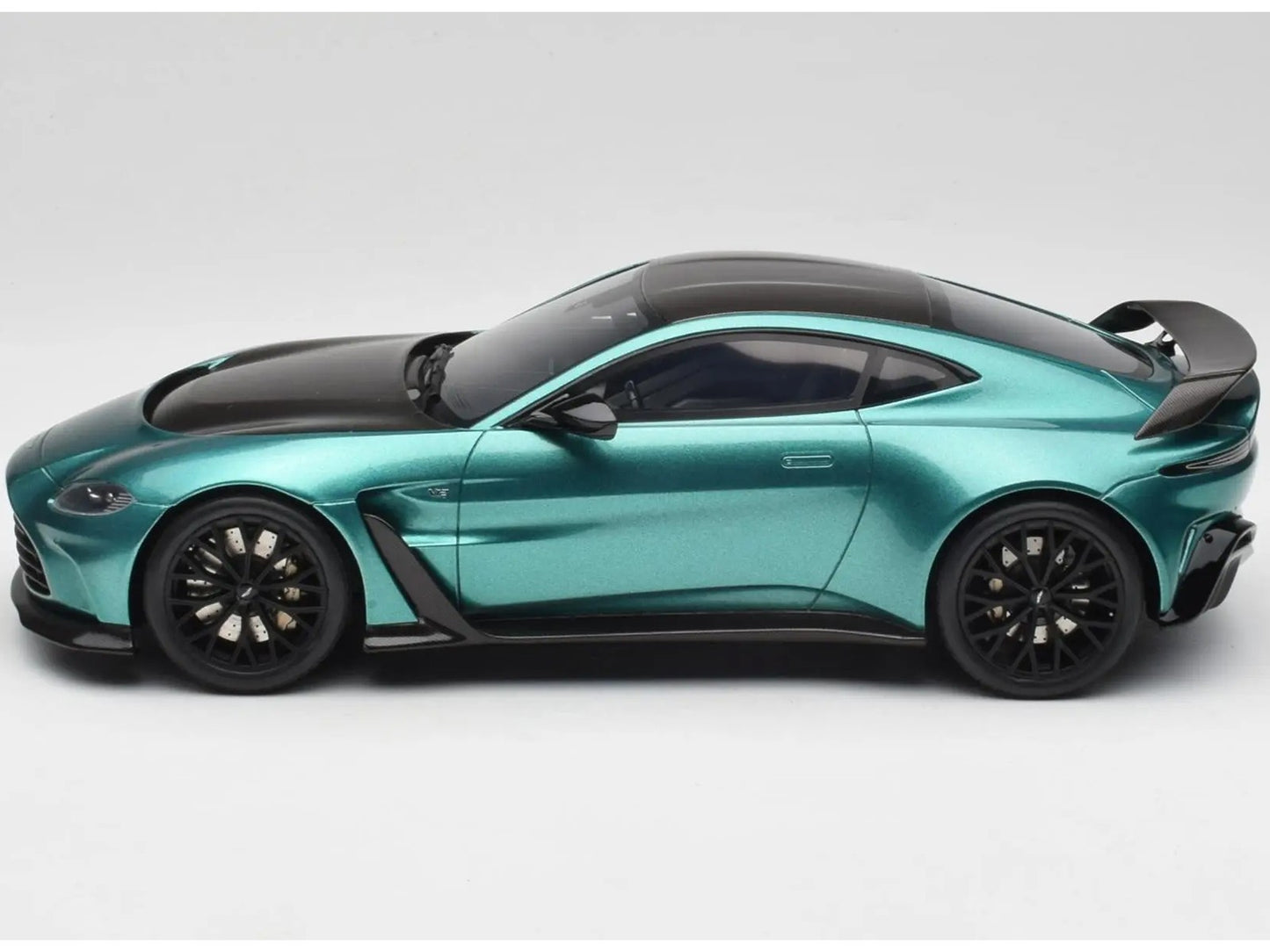 Teal sports car with black accents on a white background