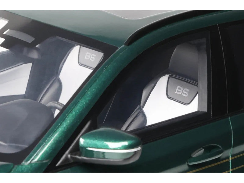 Close-up of a car's side mirror and window with '85' branding on a green vehicle.