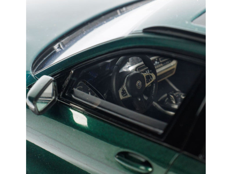 Close-up of a car's interior with a steering wheel and dashboard, reflected in the windshield.