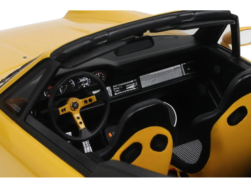 Close-up of a yellow car's interior with steering wheel and dashboard.