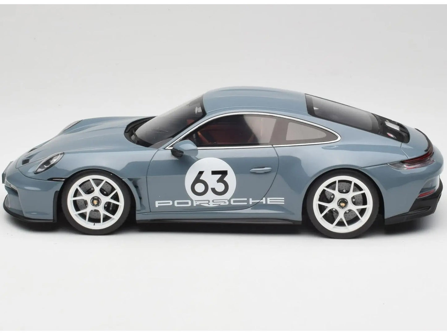 Model car of a Porsche with the number 63 on a white background