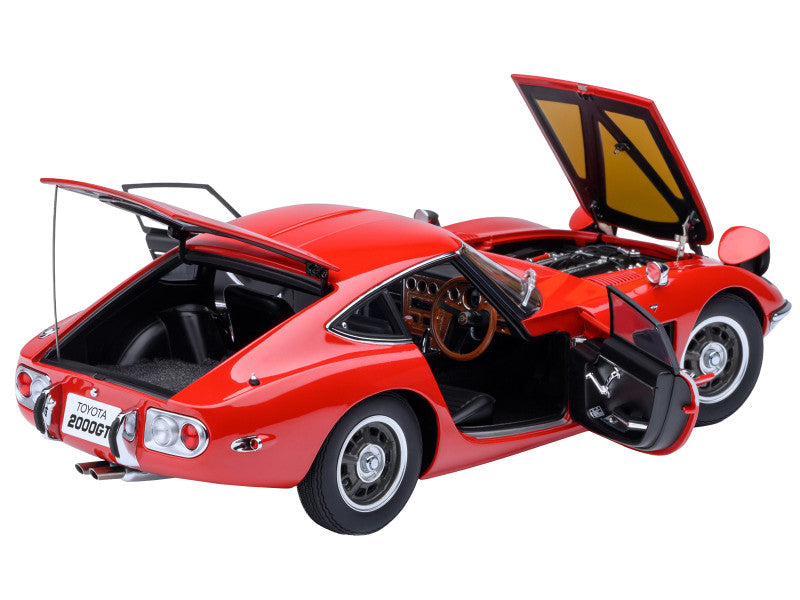 Red toy car with open doors and hood on a white background