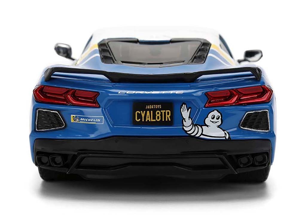 Blue Corvette with a custom license plate and sticker on a white background