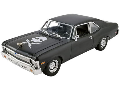 Black model car with a skull and crossbones design on the hood against a white background