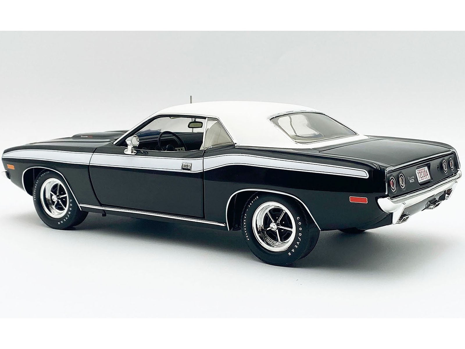 Black muscle car with white top on a gray background