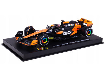 Model of a Formula 1 car on a black platform with a white background