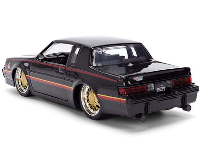 Black model car with gold wheels on a white background