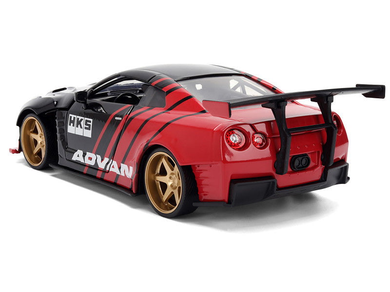 Red and black model car with gold wheels on a white background