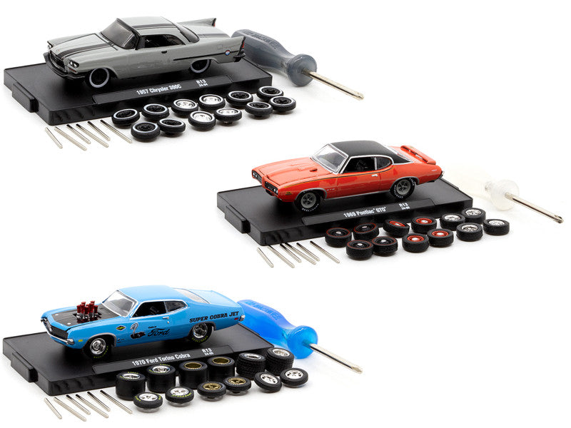 Three model cars on display stands with tools and parts on a white background