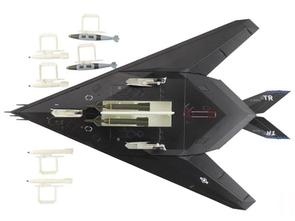 Black fighter jet model with attached missiles on a white background