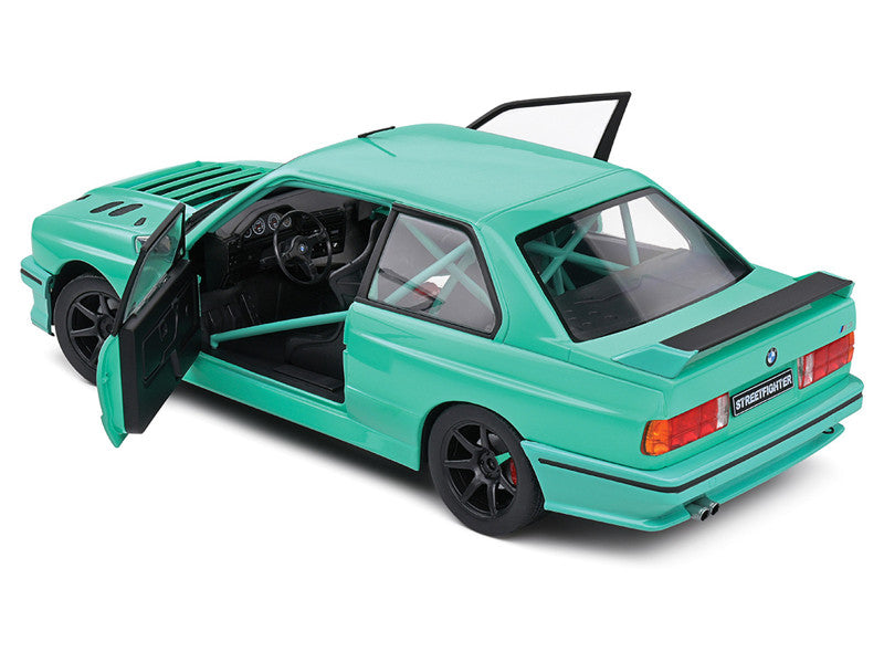 Green model car with open doors on a white background