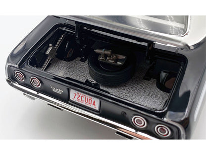 Close-up of a car's exhaust system with a 'ZCuda' license plate on a white background