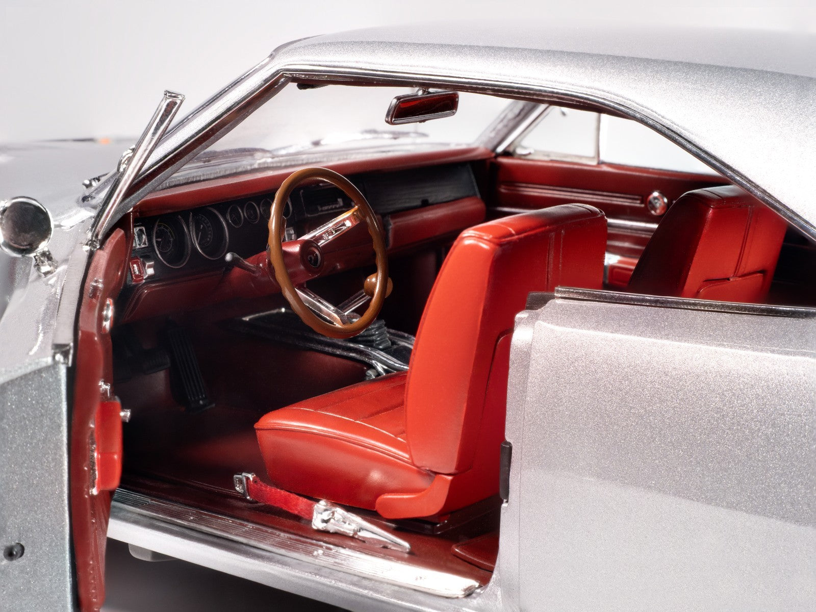 Close-up of a classic car's interior with red seats and wooden steering wheel.