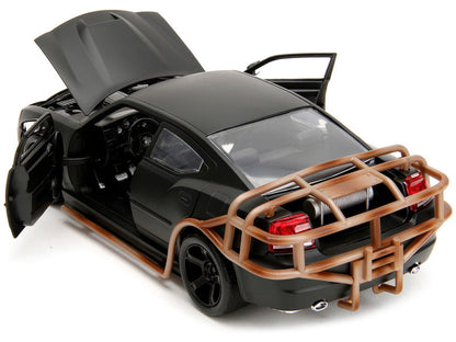 Black model car with open doors and a brown bumper on a white background