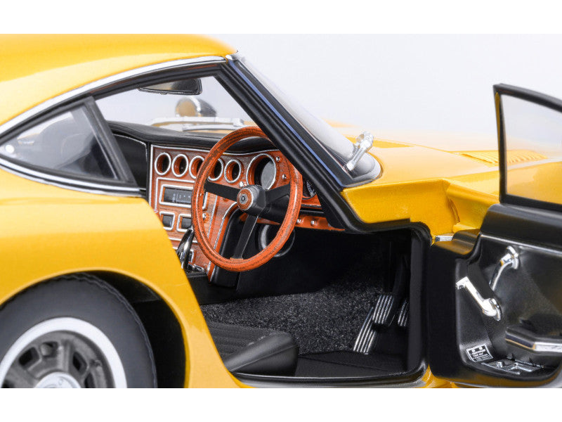 Close-up of a yellow car's interior with open door and steering wheel.