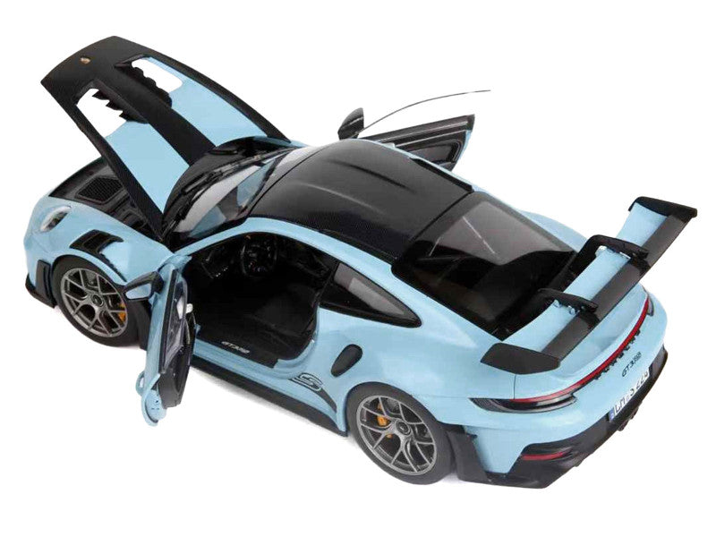 Light blue sports car with open doors on a white background