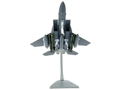Model of a fighter jet on a stand with a white background