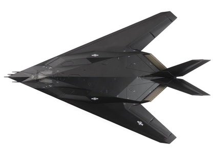 Black stealth aircraft model on a white background