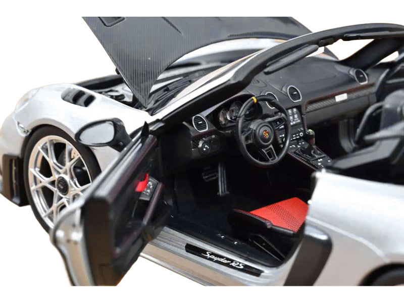 Close-up of a sports car with open door and hood, showing interior details.