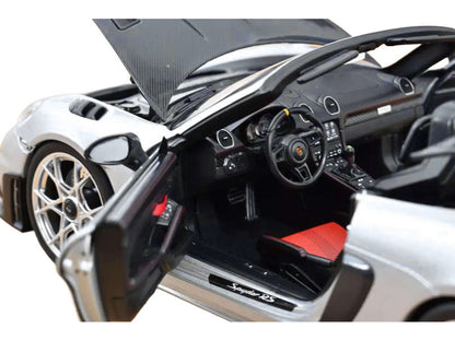 Close-up of a sports car with open door and hood, showing interior details.