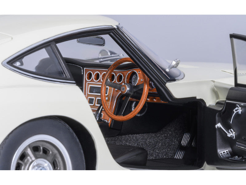 Close-up of a model car's interior with a wooden steering wheel and dashboard.
