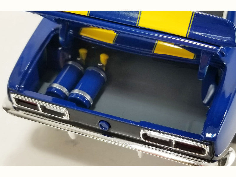Close-up of a blue and yellow car model with open trunk