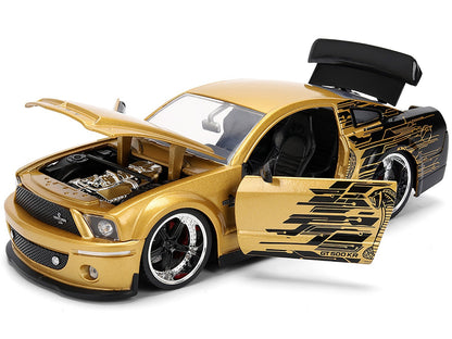 Gold toy car with open door and detailed engine on a white background