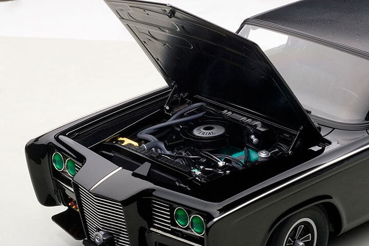 Engine compartment of black model car with green headlights