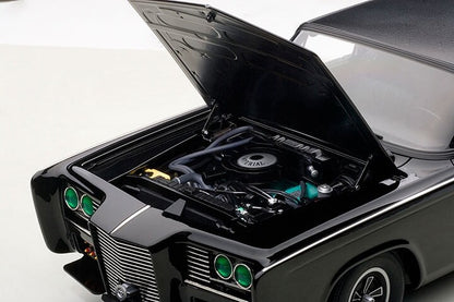 Engine compartment of black model car with green headlights