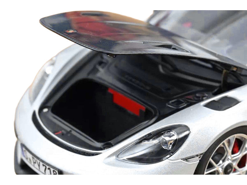 Silver car with open hood showing engine compartment