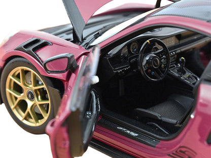 Close-up of a pink sports car with open door, showing interior details.