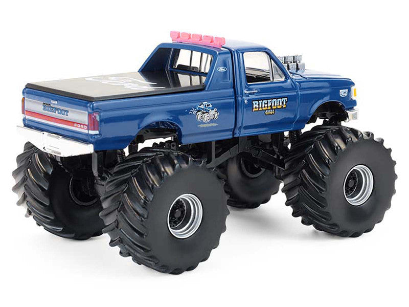 Blue monster truck model with large wheels on a white background