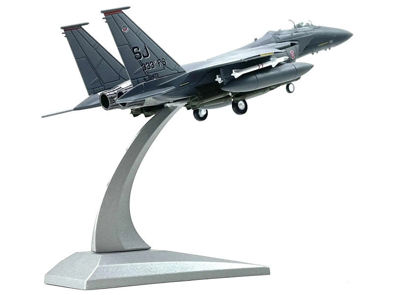Model of a fighter jet on a stand with a white background