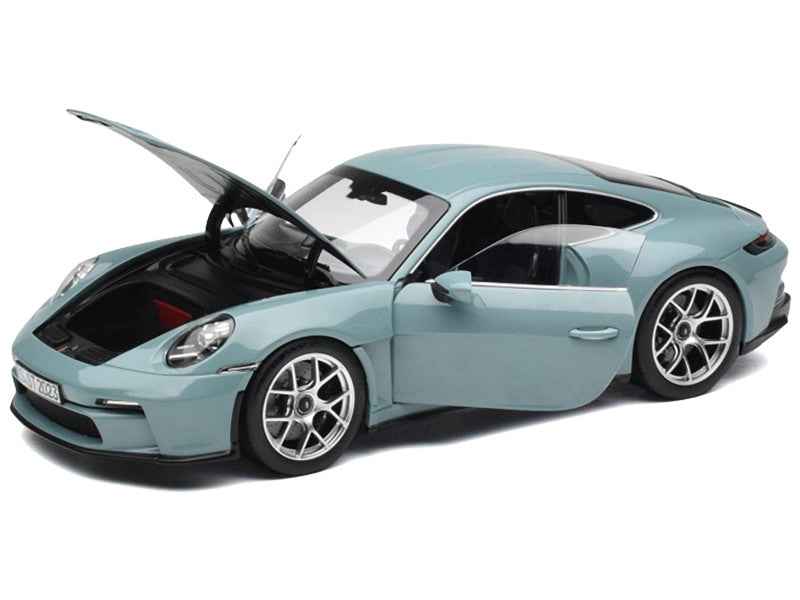 Light blue model car with open hood on a white background