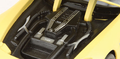 Close-up of a car's engine bay with visible branding on a yellow car.